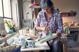 Susanne Altzweig, Keramikerin aus Höhr-Grenzhausen dekoriert eine Keramikschale.
